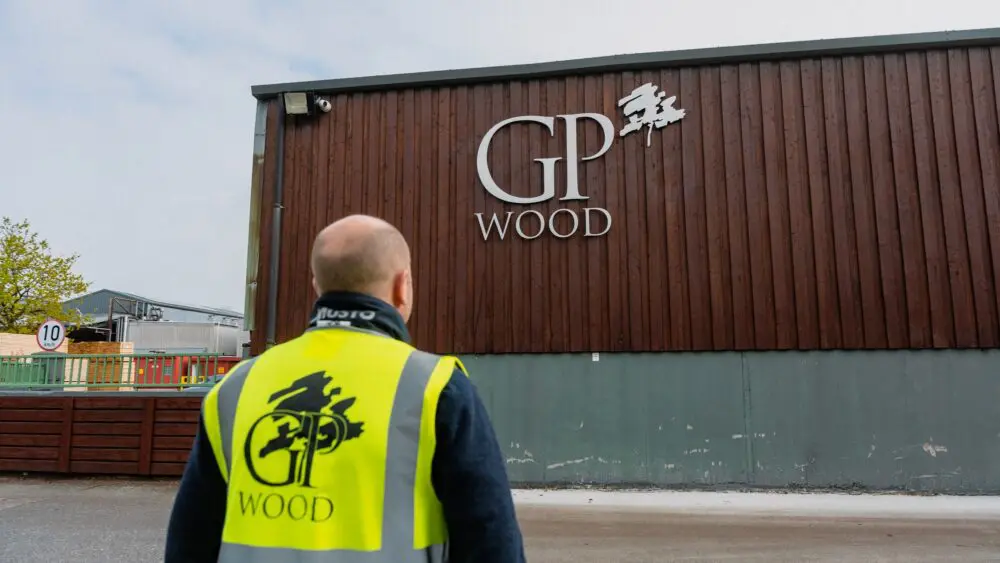 GP Wood employee in front of the company sign