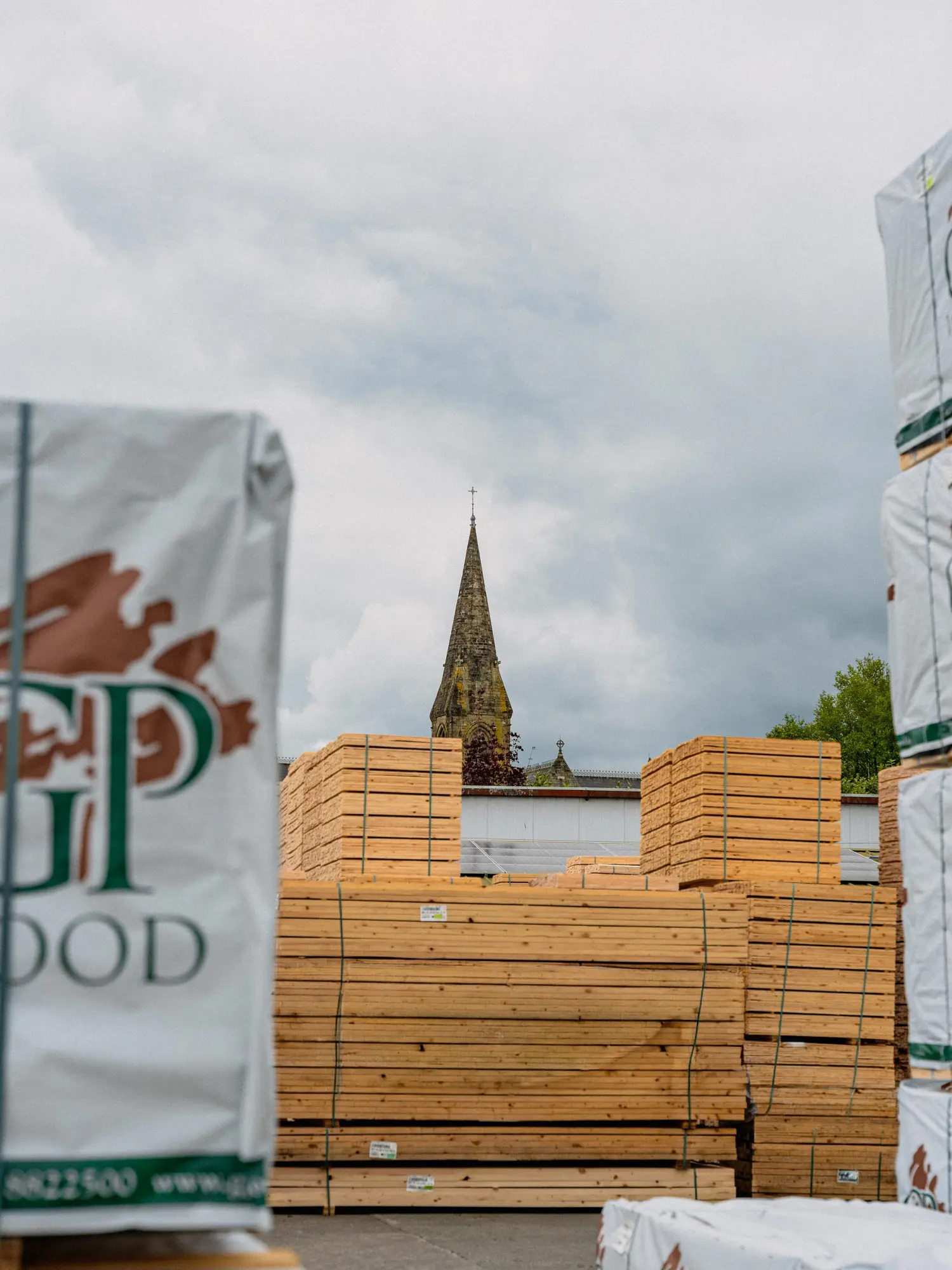Branded timber packs in the GP Wood yard with village church in the background